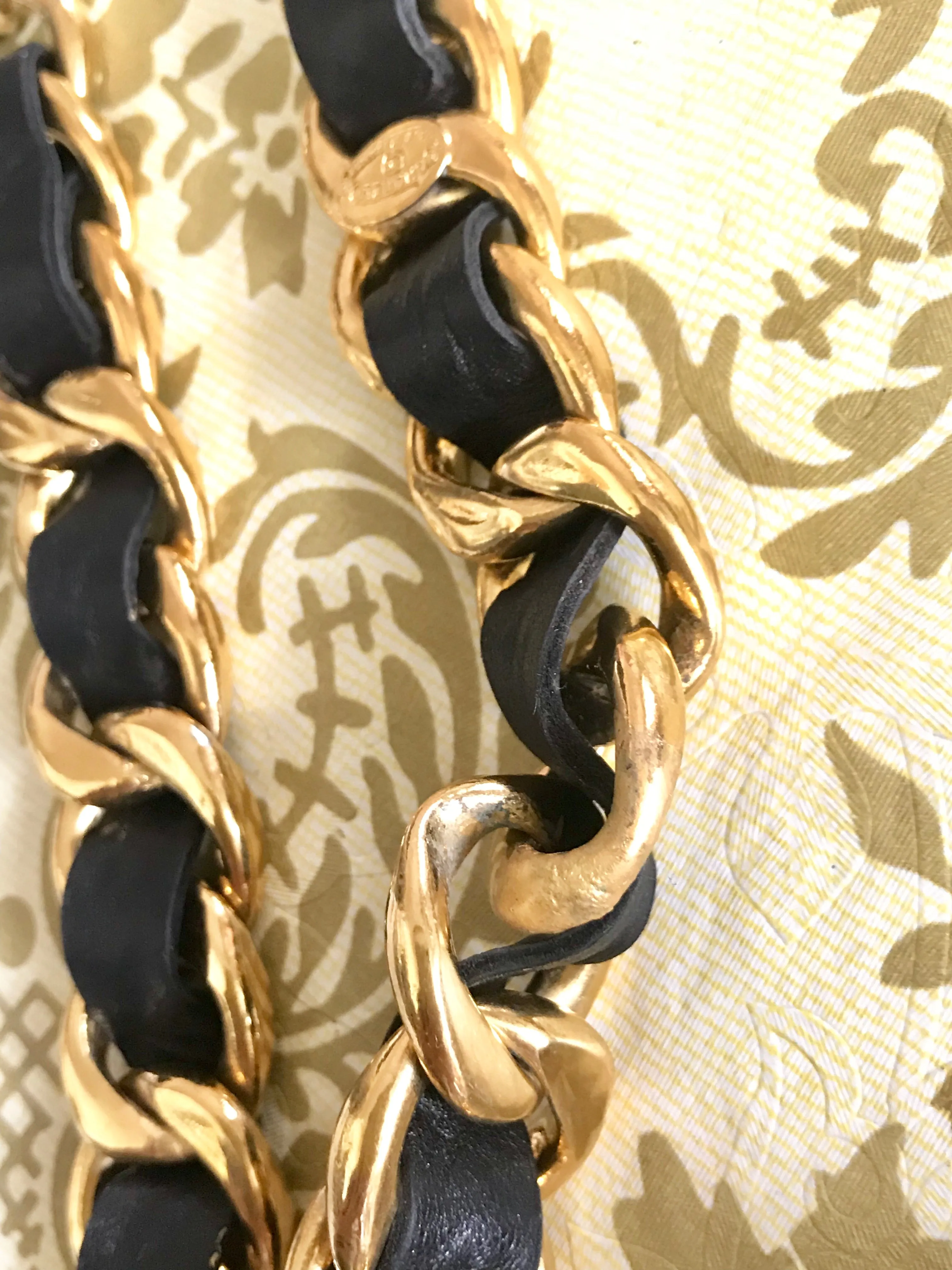1980s Vintage CHANEL black leather thick chain belt with golden CC and mademoiselle charm. Nice and heavy single layer belt from CHANEL.