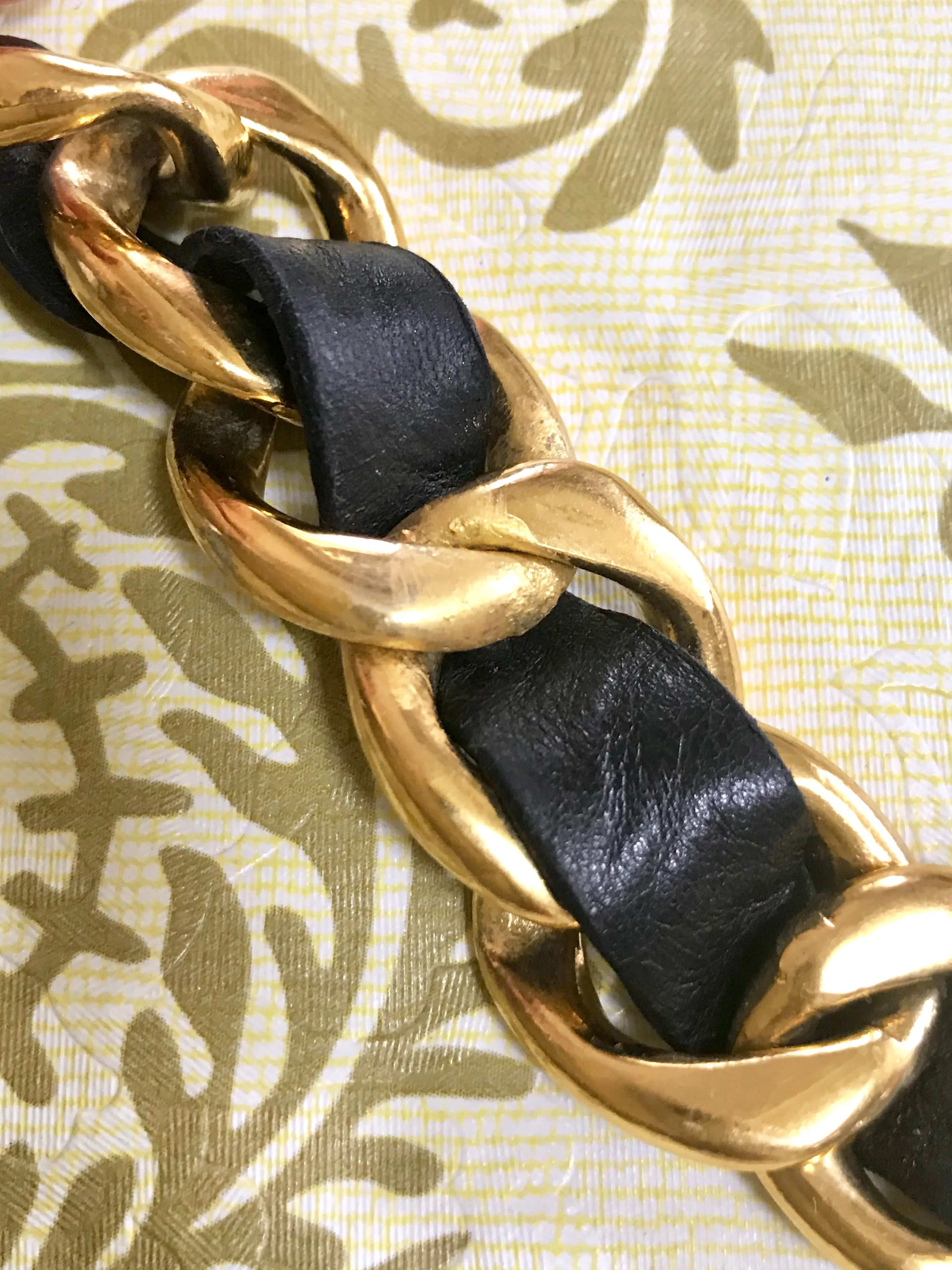1980s Vintage CHANEL black leather thick chain belt with golden CC and mademoiselle charm. Nice and heavy single layer belt from CHANEL.