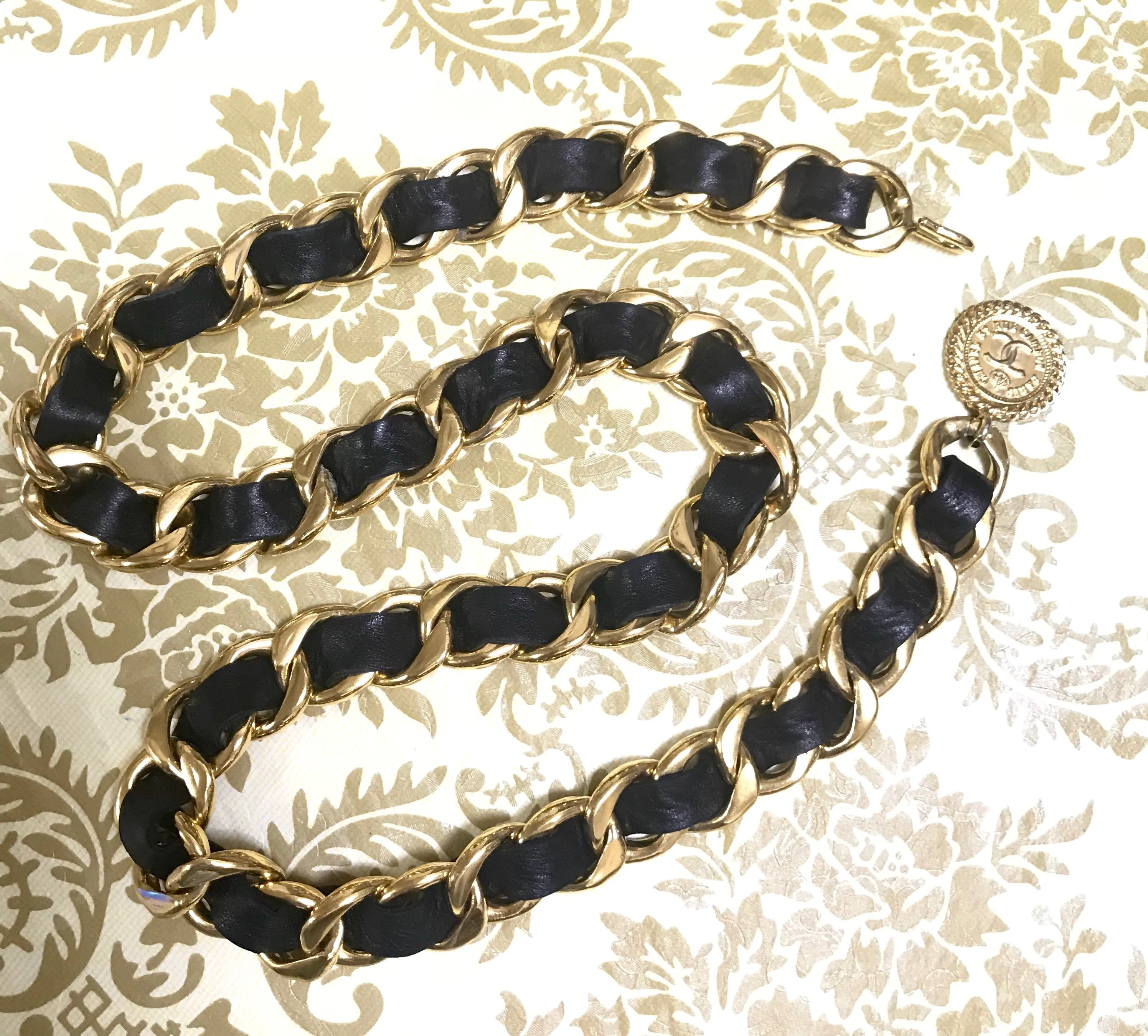 1980s Vintage CHANEL black leather thick chain belt with golden CC and mademoiselle charm. Nice and heavy single layer belt from CHANEL.