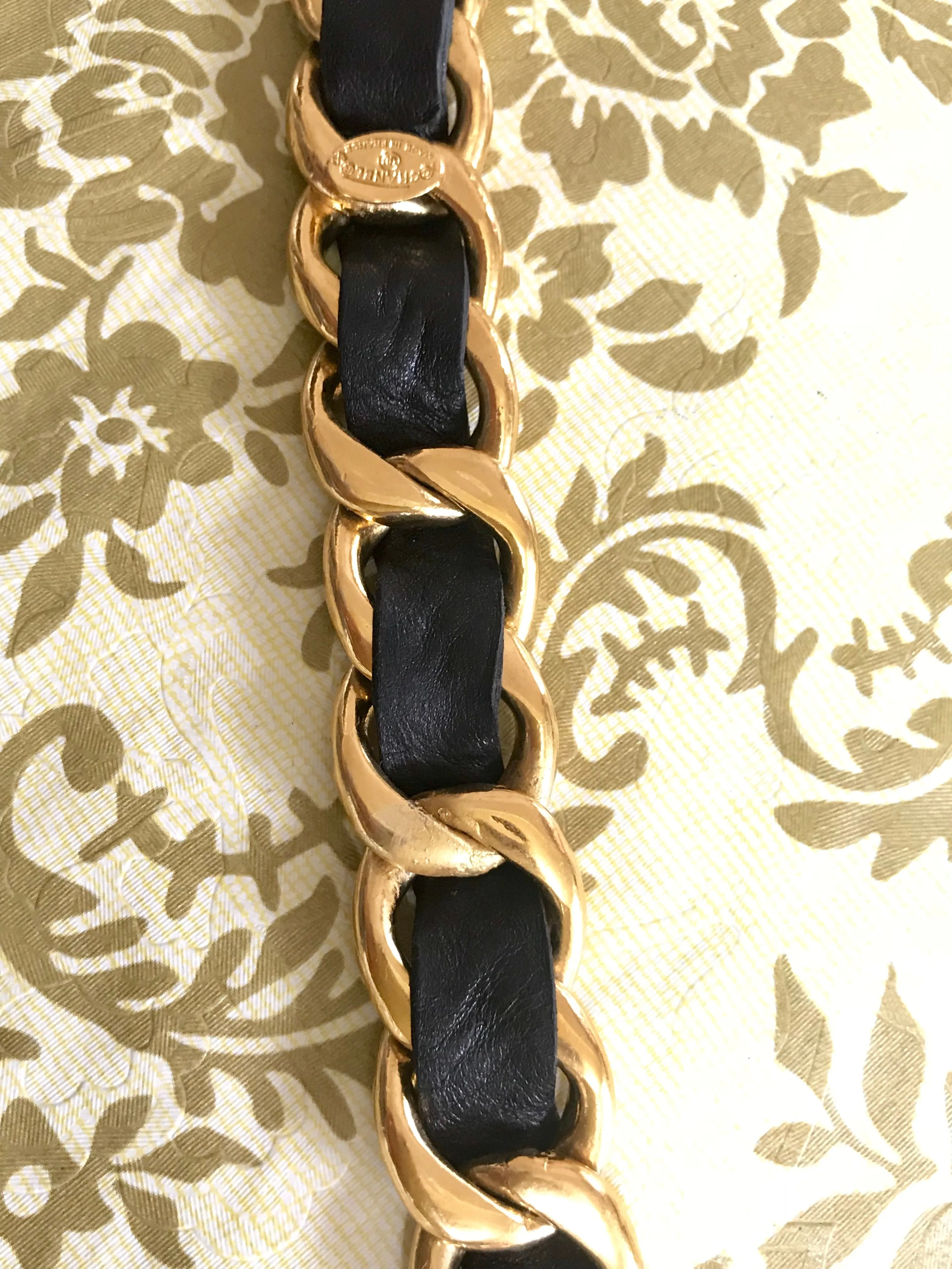 1980s Vintage CHANEL black leather thick chain belt with golden CC and mademoiselle charm. Nice and heavy single layer belt from CHANEL.