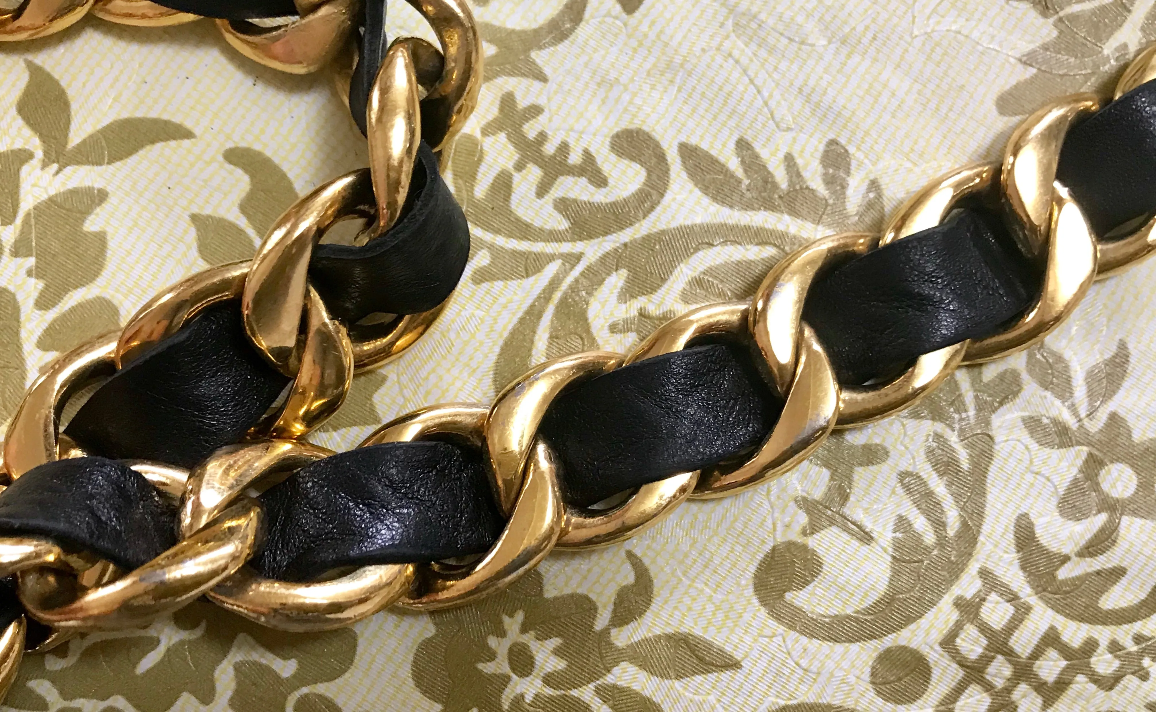 1980s Vintage CHANEL black leather thick chain belt with golden CC and mademoiselle charm. Nice and heavy single layer belt from CHANEL.