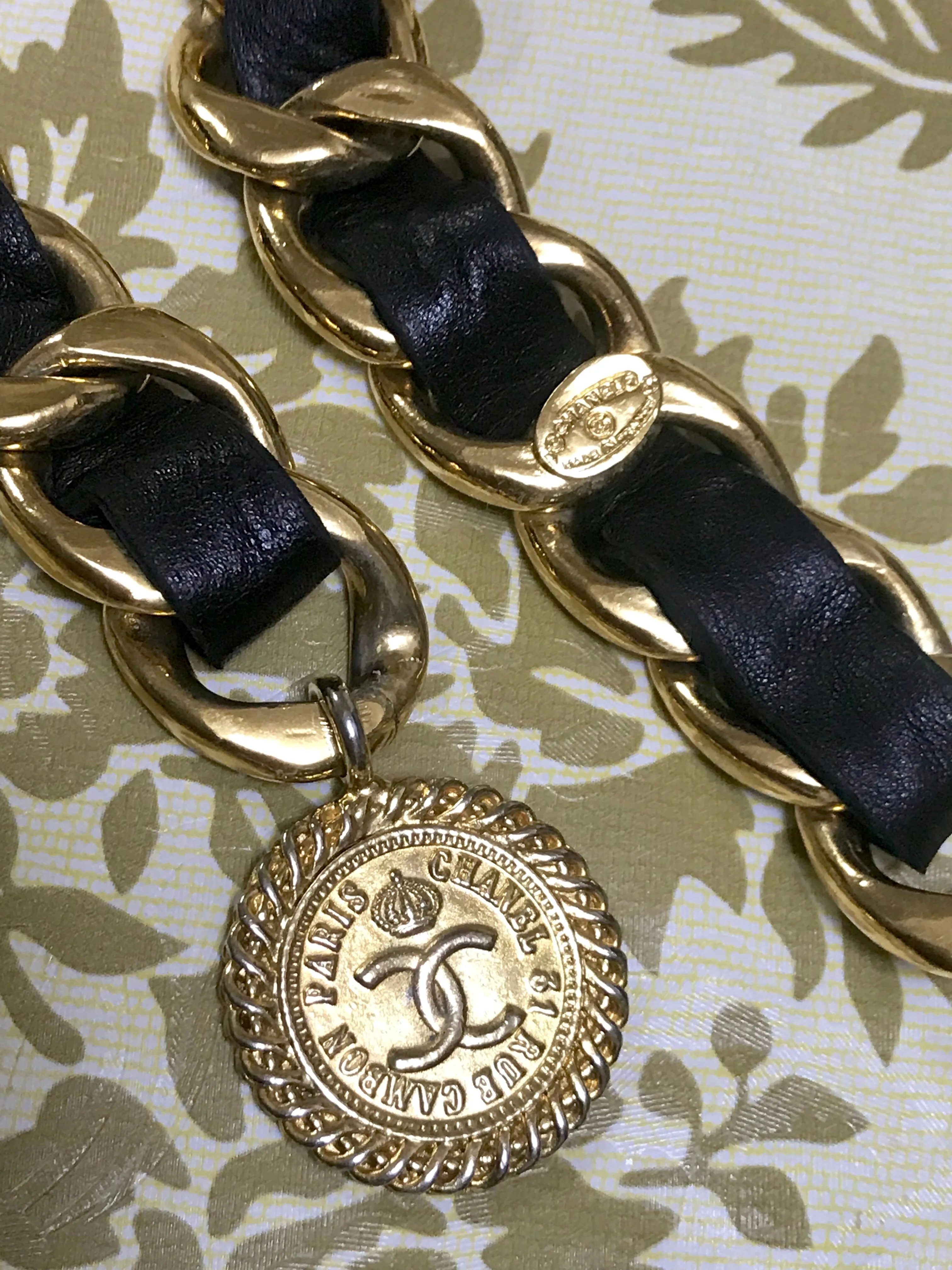 1980s Vintage CHANEL black leather thick chain belt with golden CC and mademoiselle charm. Nice and heavy single layer belt from CHANEL.